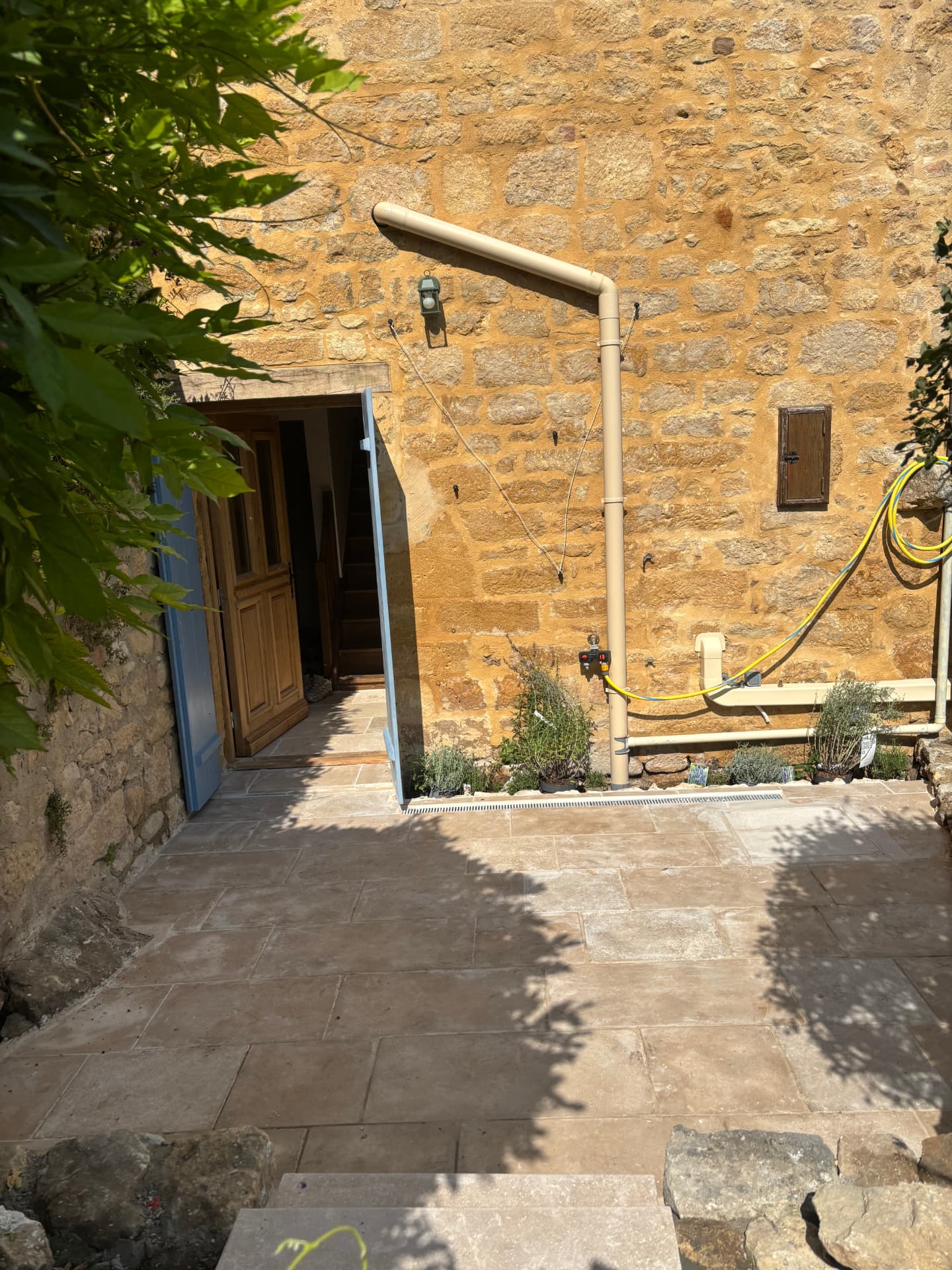 Finished natural stone patio beside the stone facade in La Roque-Gageac, Dordogne