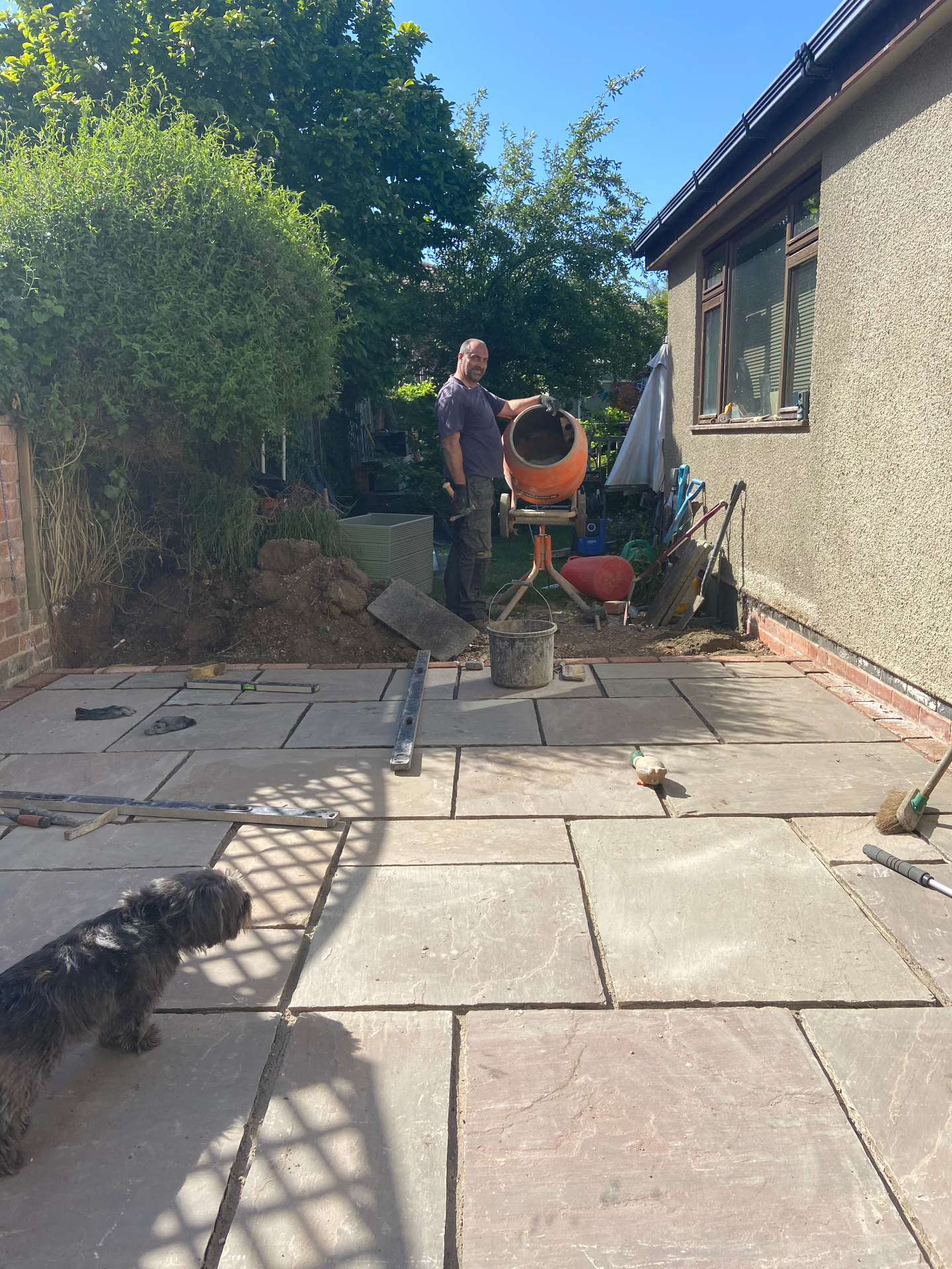Sandstone patio being laid, with cement mixer on site