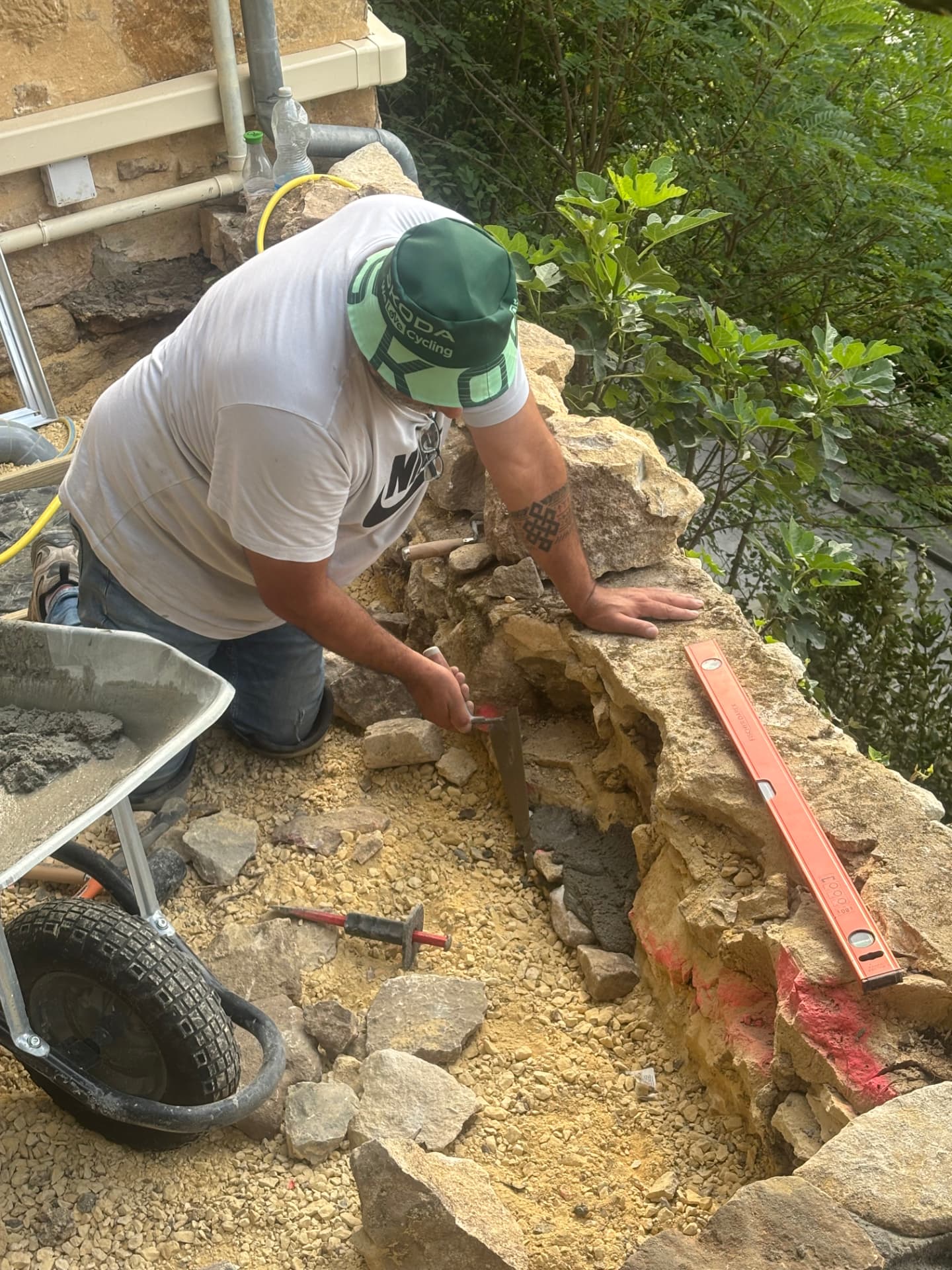 Rebuilding and repairing the stone wall with mortar and spirit level
